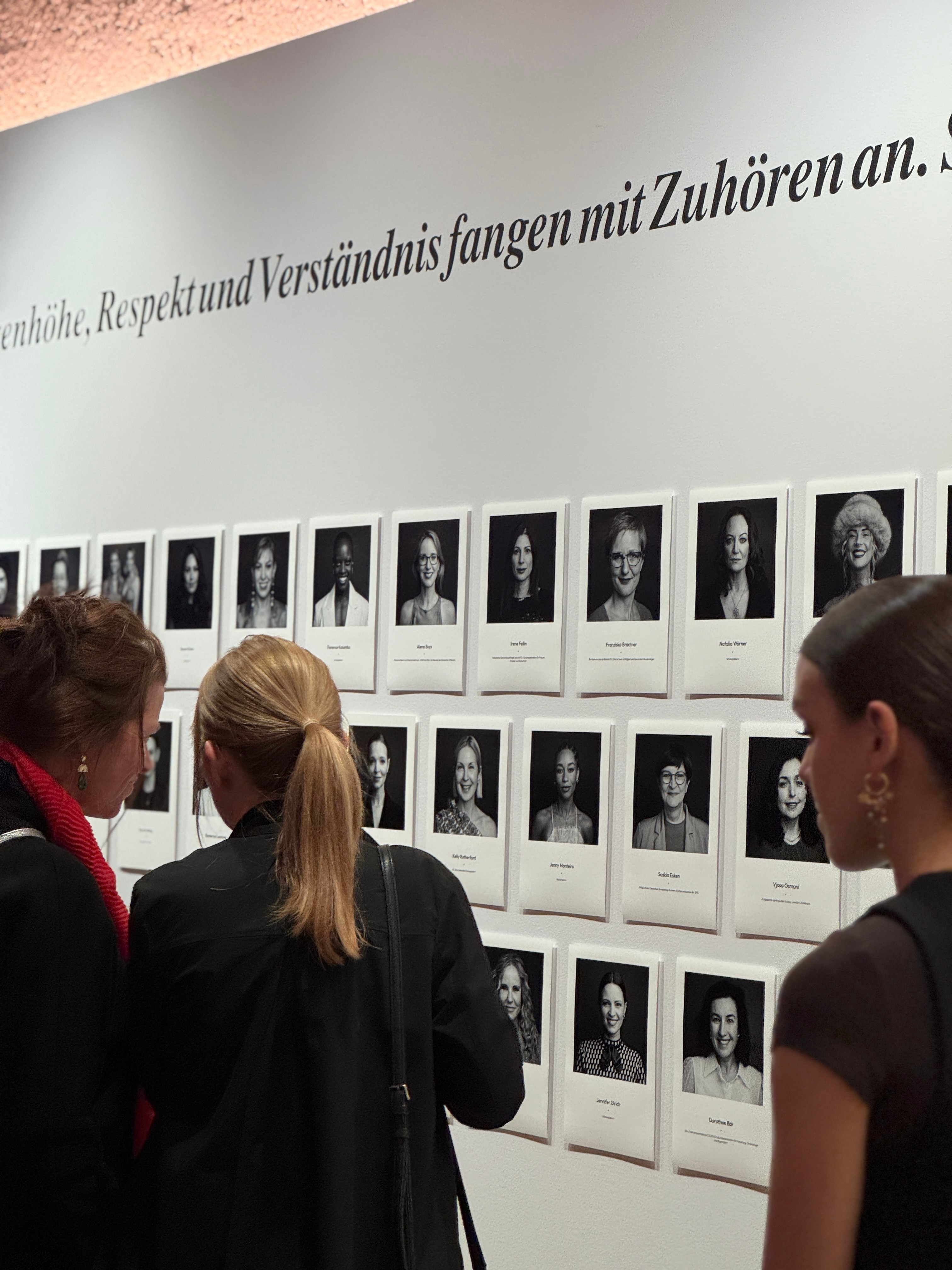 Ausstellungsbesucherinnen vor einer gehängten Portraitserie